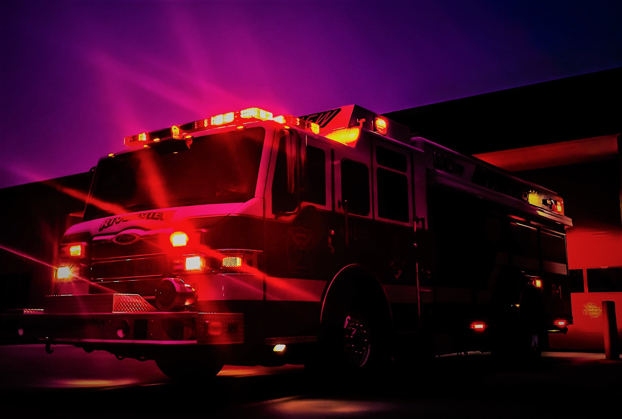 A Riverview Fire Department truck with lights flashing at night